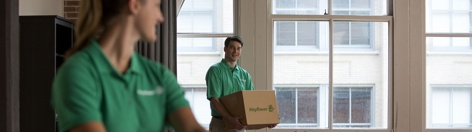 Two movers with box in apartment