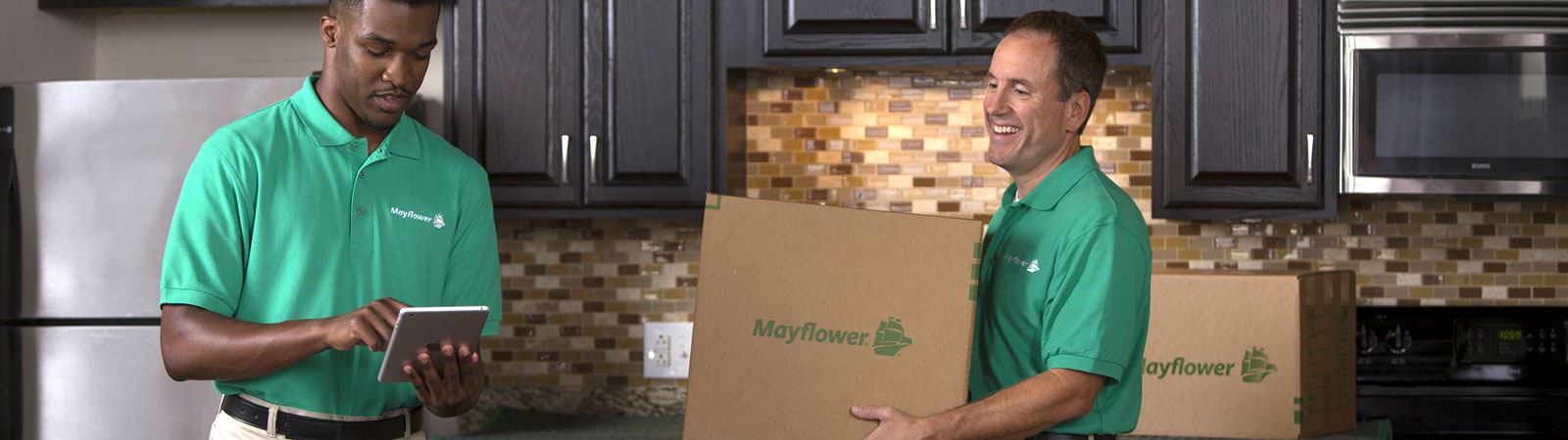 Two movers with boxes in kitchen